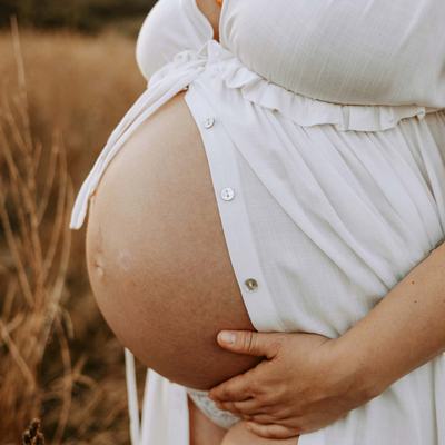 Eine schwangere Frau. Das Bild zeugt ihren Bauch.